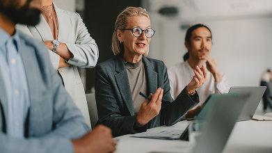 A woman seated, leading discussion at a table